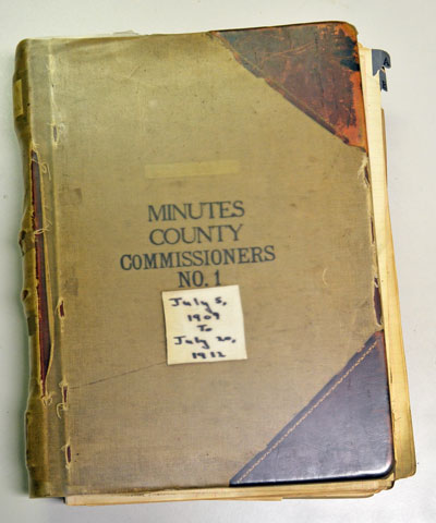 The Board of County Commissioners meeting minutes from July 5, 1909 to July 10, 1912 are archived in a book with a canvas cover and leather corners.