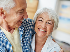 Older man and woman hugging each other.