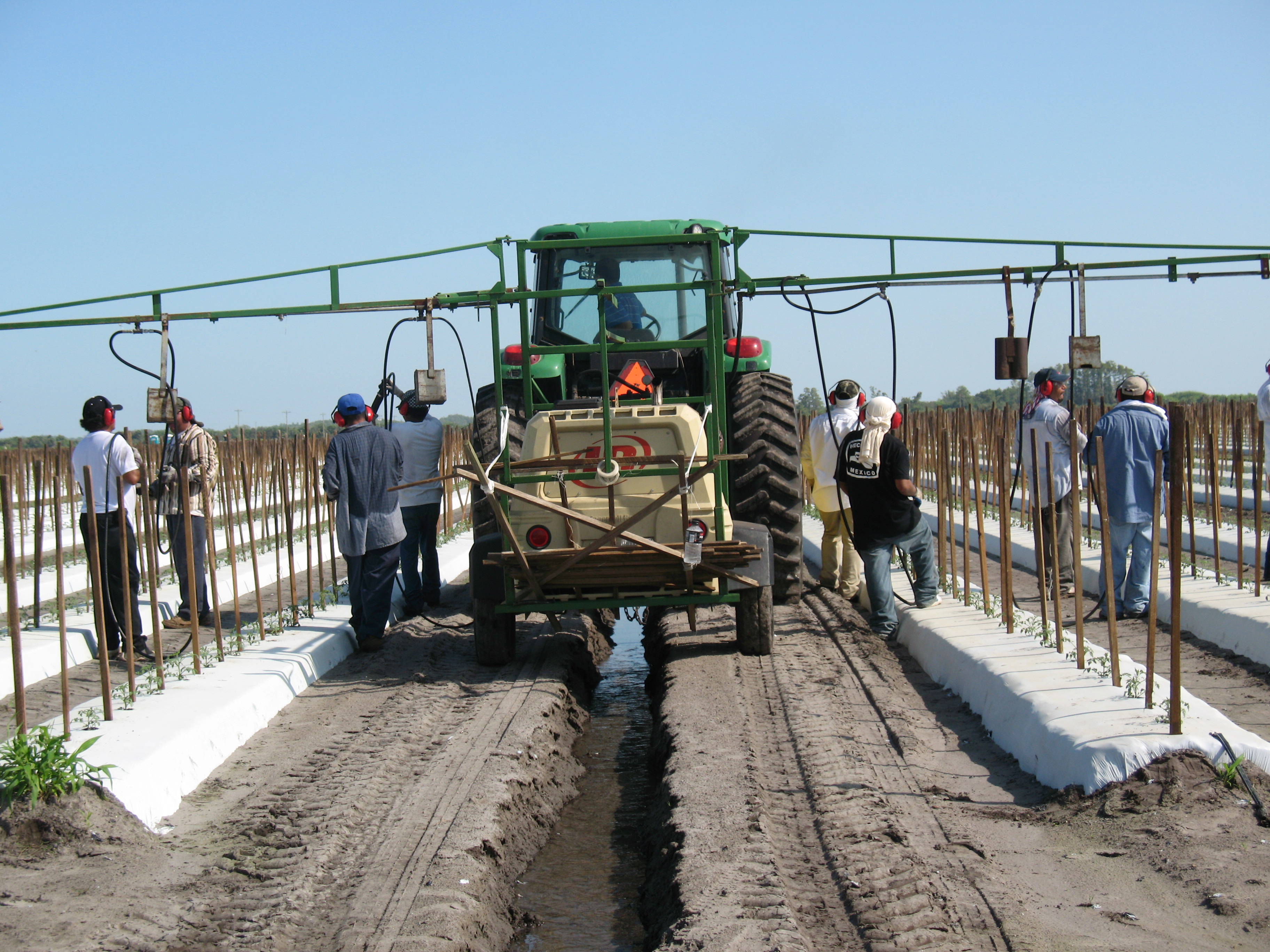 Several workers surrounding tractor