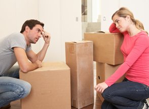 Young couple man and woman surrounded by boxes.