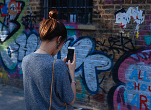 teen taking picture of graffiti with phone