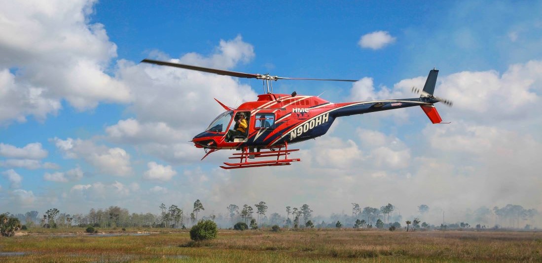 Image of helicopter flying over natural area