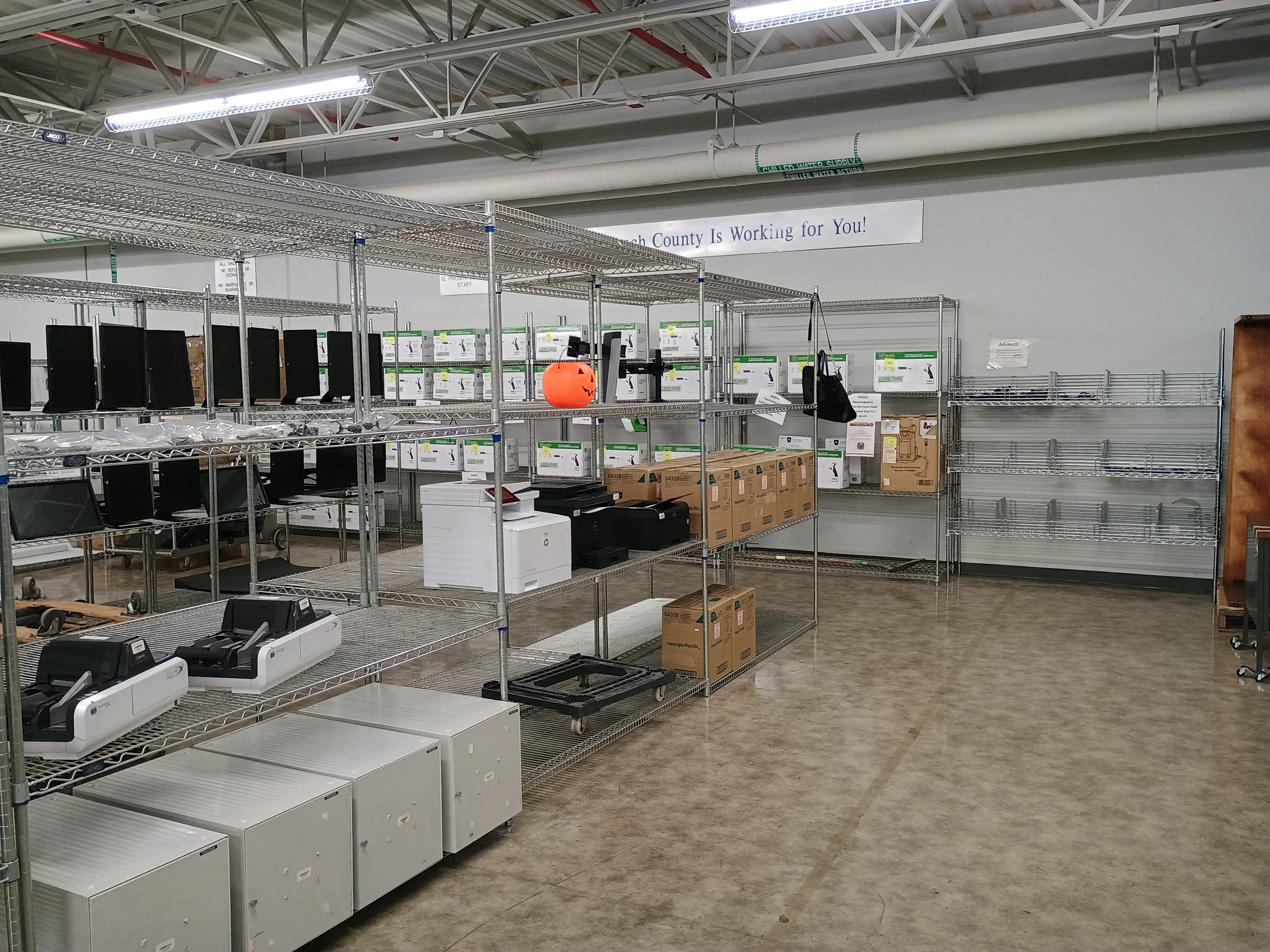 Metal wire racks with various merchandise, Printers, pumpkin pail, paper towel dispensers.jpg