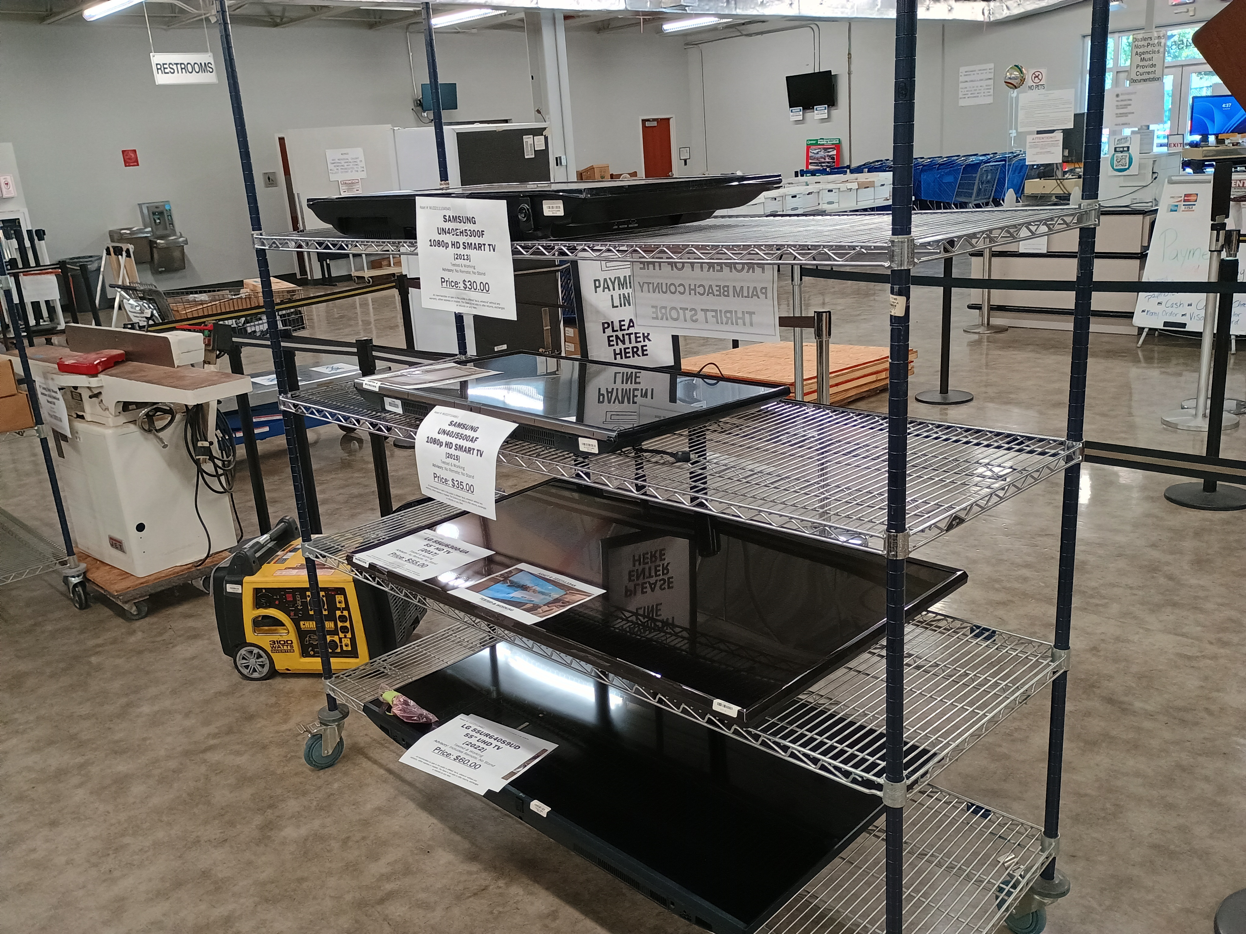 Mobile metal shelf with four televisions.jpg